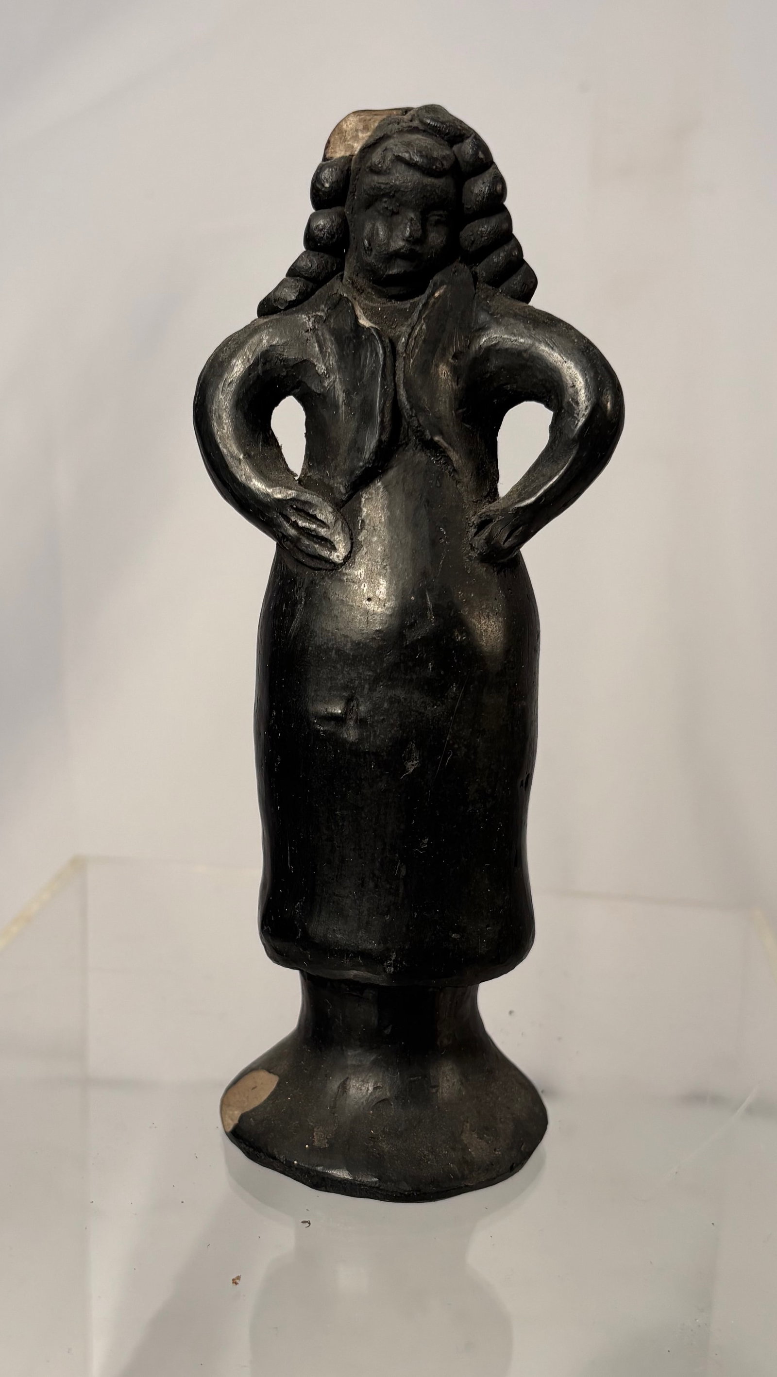 Folk Art Black Terracotta Dancing girl Figurine: Handmade black terracotta folk-art figurine, likely produced in the mid-20th century. The figure depicts a stylized woman with hands on hips, featuring exaggerated braided hair and a flared base.