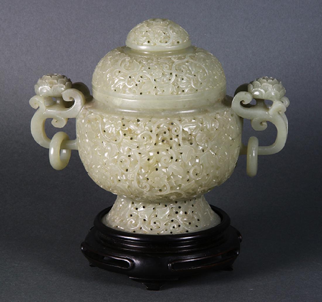 Chinese Pierced Hardstone Censer: Chinese hardstone pierced censer, with a domed lid and a body reticulated with floral tendrils, flanked handles carved with blossoms and suspending loose rings, with wood stand, censer: 7.25"w