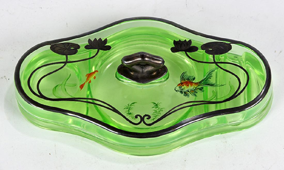 Art Nouveau green glass ink stand: Art Nouveau green glass ink stand, having a lid with silver metal mounts and inlaid floral decoration, the interior with a central round well flanked by a smaller round well to one side, the other wit