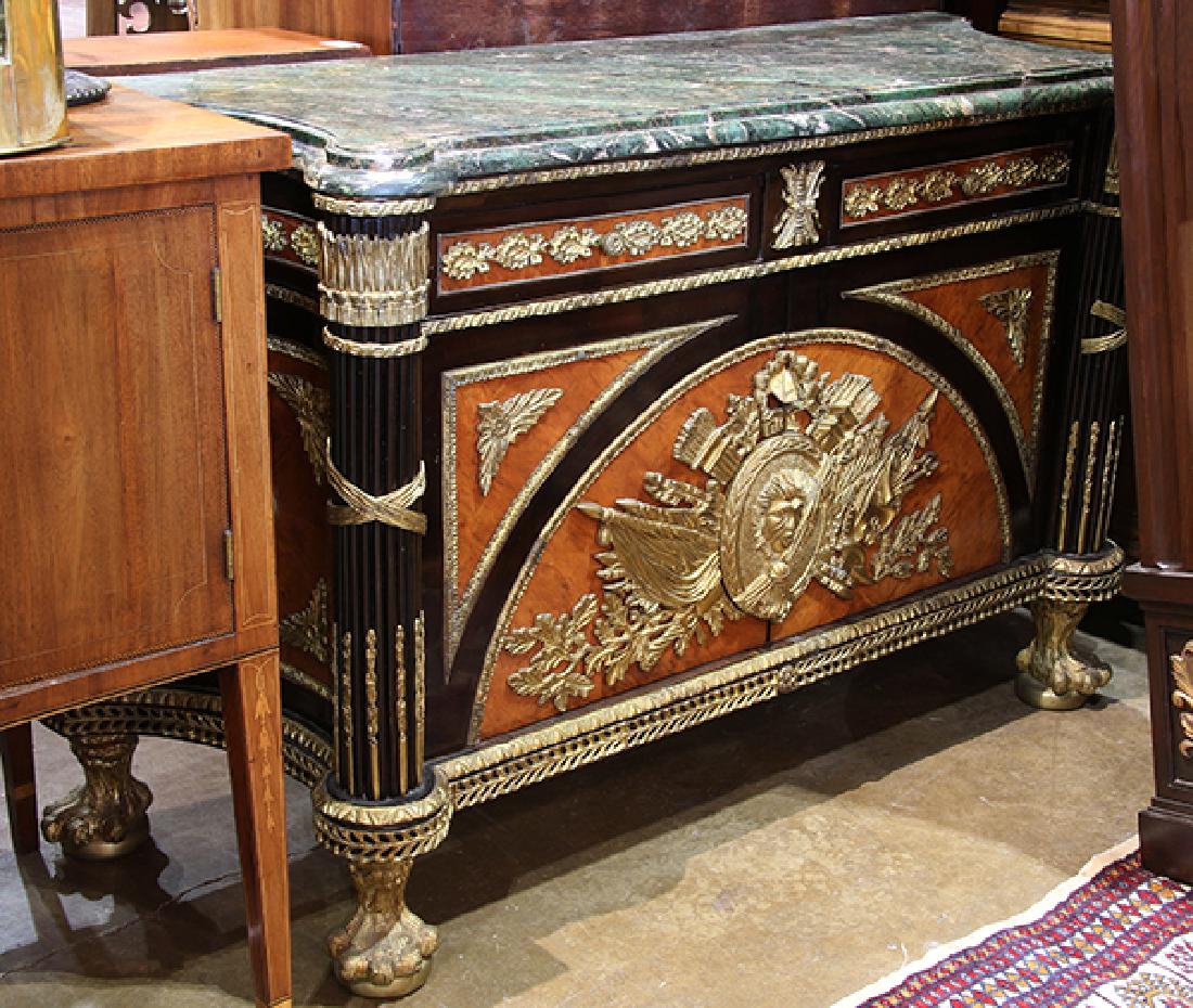 French Empire style gilt mounted mahogany sideboard: French Empire style gilt mounted mahogany sideboard, having a shaped marble top, above the two drawer case, centered with a lion medallion, and rising on paw feet, 36"h x 60"w x 22"d