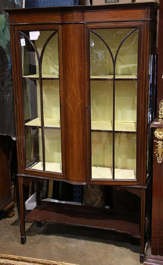 Edwardian mahogany and satinwood vitrine, the molded: Edwardian mahogany and satinwood vitrine, the molded cornice above double glass doors with mullion accents, surmounting the lower case fitted with satin lined shelves and rising on sabot feet, 66"h x 