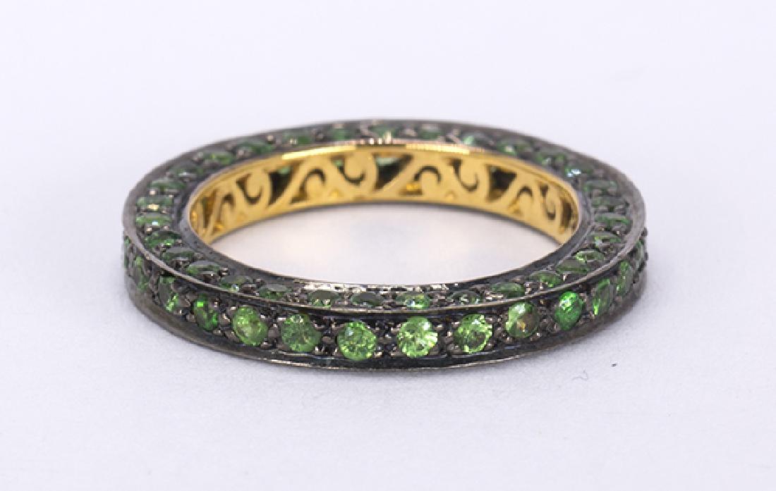 Tsavorite garnet and silver gilt eternity band: Tsavorite garnet and silver gilt eternity band featuring (91) round-cut tsavorite garnets, weighing a total of approximately 0.75 ct., set in a blackened and silver gilt eternity mounting, measuring a