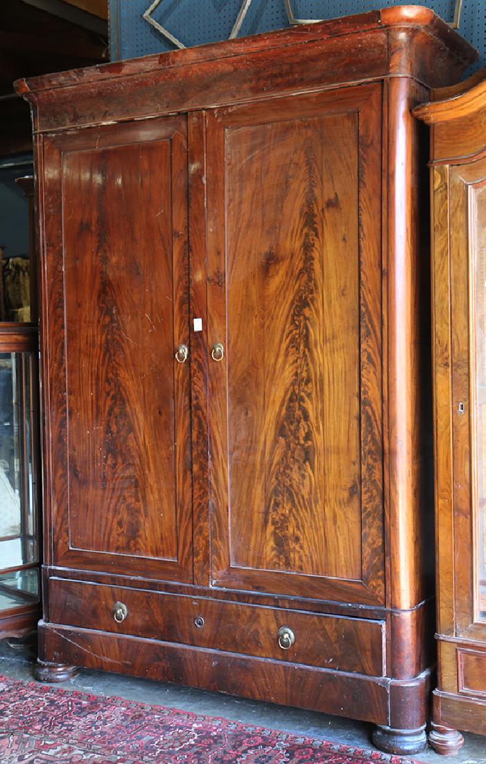 Empire flame mahogany linen press: Empire flame mahogany linen press, 19th century, having a rounded corner crown over long double doors, opening to a fitted interior, above two lower drawers, the whole rising on flattened bun feet, 96