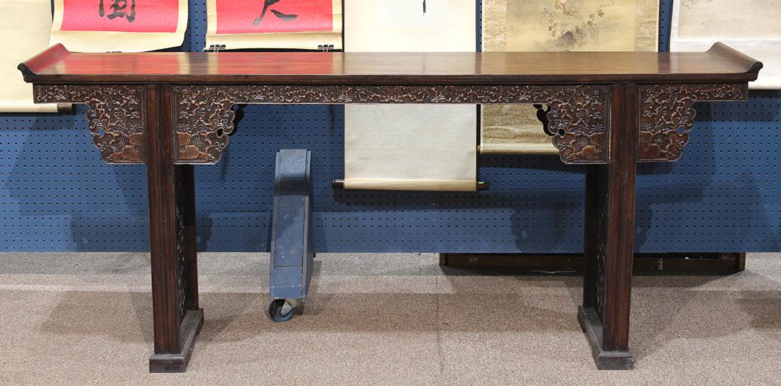 Chinese Altar Table, Lingzhi: Chinese hardwood altar table, inset with a single floating panel flanked by flanges, the apron carved with lingzhi, on trestle supports with side panels repeating lingzhi motif, 79.5"w