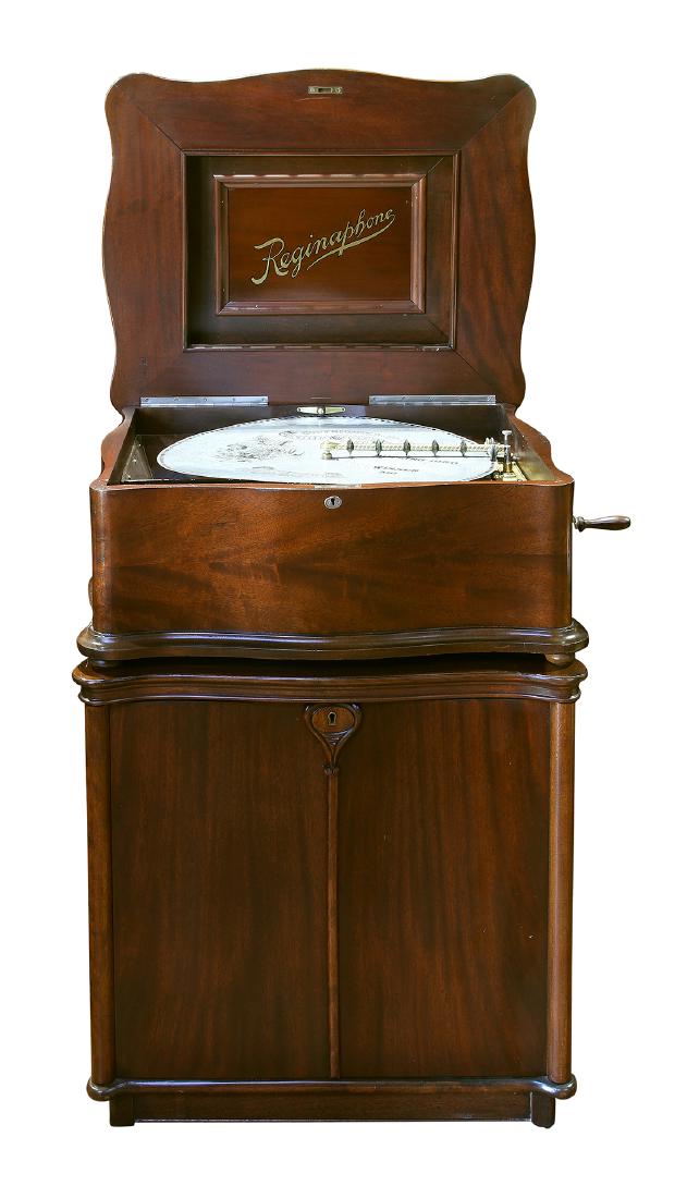 Reginaphone upright music box playing 21" discs: Reginaphone upright music box playing 21" discs, having a mahogany case, with original stand housing the conversion kit to convert to a phonograph, has all phonograph components including tone arm, tu
