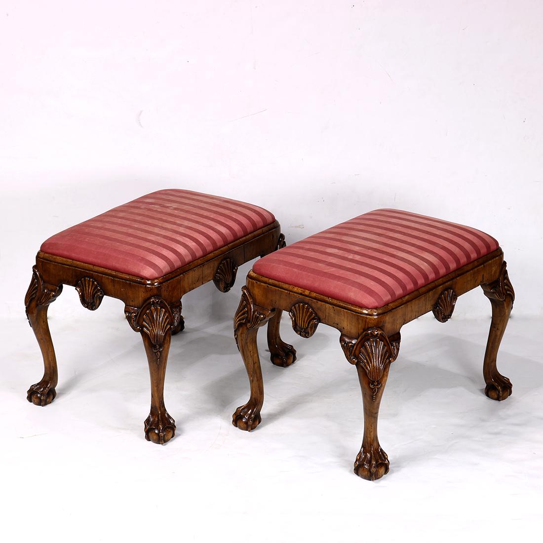 Pair of Chippendale style ottomans, having an: Pair of Chippendale style ottomans, having an upholstered seat, with an apron having a carved shell medallion, the knees accented with carved shell medallions, and rising on cabriole legs terminating