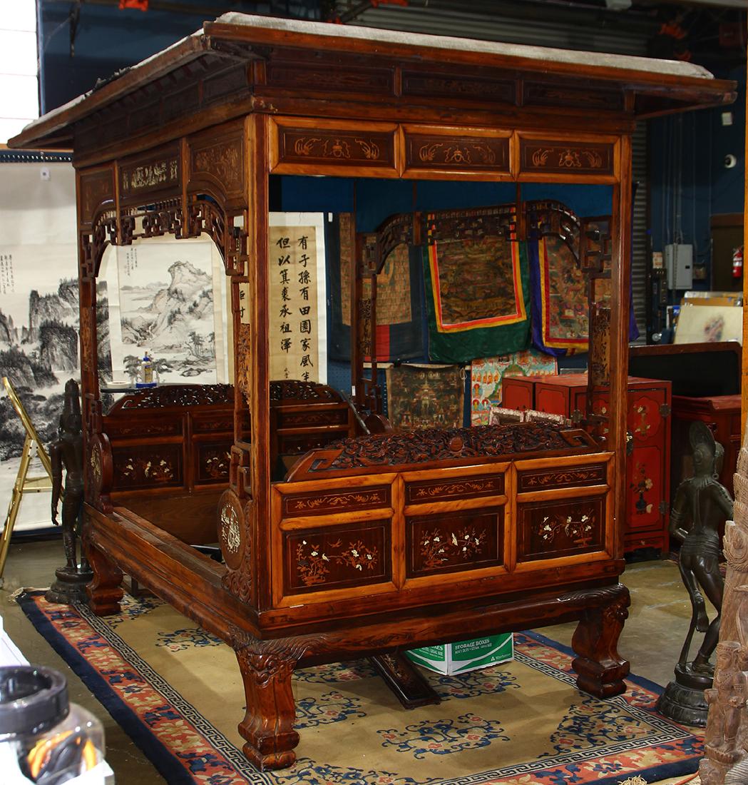 Chinese Wood Canopy Bed: Chinese wooden canopy bed, inset carved wood panels some with bone inlay with scenes of landscapes, bird-and-flowers along with figures, raised on supports with fu-lion heads and paw-and-ball terminal