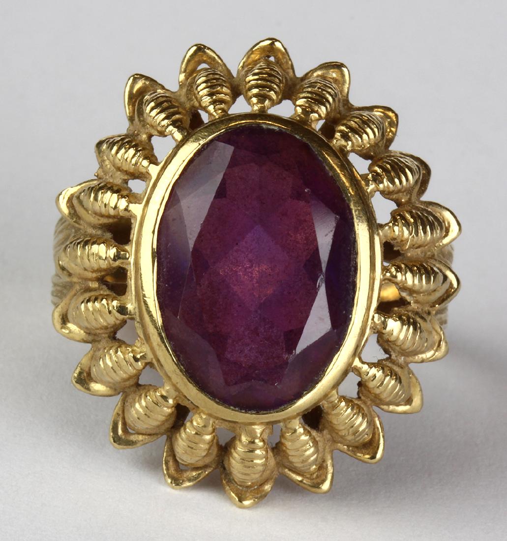 Synthetic alexandrite-like corundum and 14k yellow gold: Synthetic alexandrite-like corundum and 14k yellow gold ring Featuring (1) oval-cut synthetic alexandrite-like corundum, set in a 14k yellow gold floral motif mounting, size 8 1/2, gross weight 9.93 g