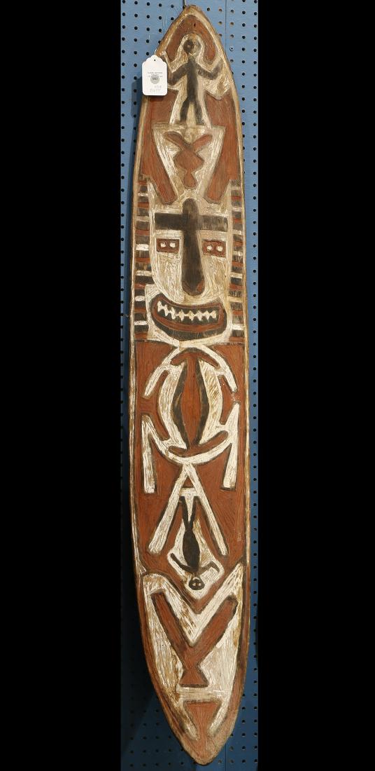 Papua New Guinea Gope board: Papua New Guinea Gope board, having an interesting but rather late or post-classic decoration of a whimsical face and two dancing figurines, red white and black, 59"h x 10"w