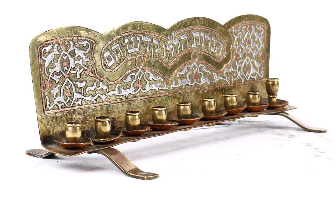 Silvered and gilt menorah: Silvered and gilt menorah, having stylized geometric detail flanking the Hebrew text