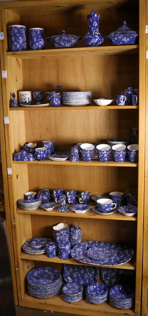 Four shelves of Staffordshire "Calico" table articles: Four shelves of Staffordshire "Calico" table articles, consisting of (14) dinner plates, (10) fruit bowls, (14) butter plates, (12) soup bowls, coffee pot, teapot, large serving platter, serving plate