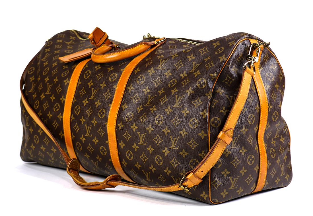 Louis Vuitton Keepall Bandouliere 60 travel bag: Louis Vuitton Keepall Bandouliere 60 travel bag, executed in brown monogram coated canvas with brown vachetta leather straps, trim and handles and brass hardware, with a luggage tag; 13.5"h x 24"w x 1