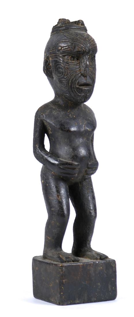 Maori figure: Maori figure, New Zealand, 1930s, depicted standing, and having incised facial deocration, with hands resting on stomach, and rising on a plinth base, probably created for the Western market, 12.5"h