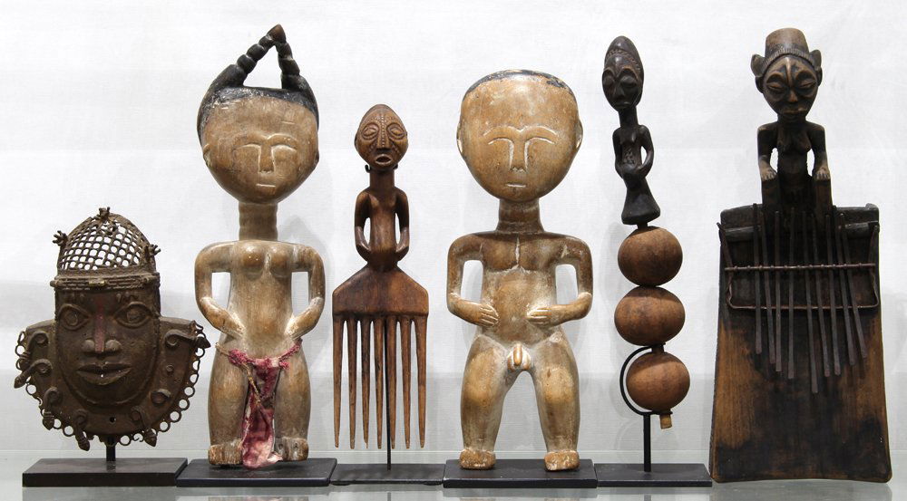 African carved wood and bronze group, consisting of a: (lot of 6) African carved wood and bronze group, consisting of a Benin bronze hip mask, West Africa, with openwork cap, and small mudfish, with slight reddish area down the nose, as was common on old