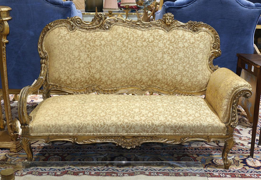 Louis XV style giltwood settee, having an ornately: Louis XV style giltwood settee, having an ornately carved crestrail featuring leaf, scroll and figural motifs, over the upholstered back and seat, rising on cabriole legs, 42"h x 62.5"w x 25"d