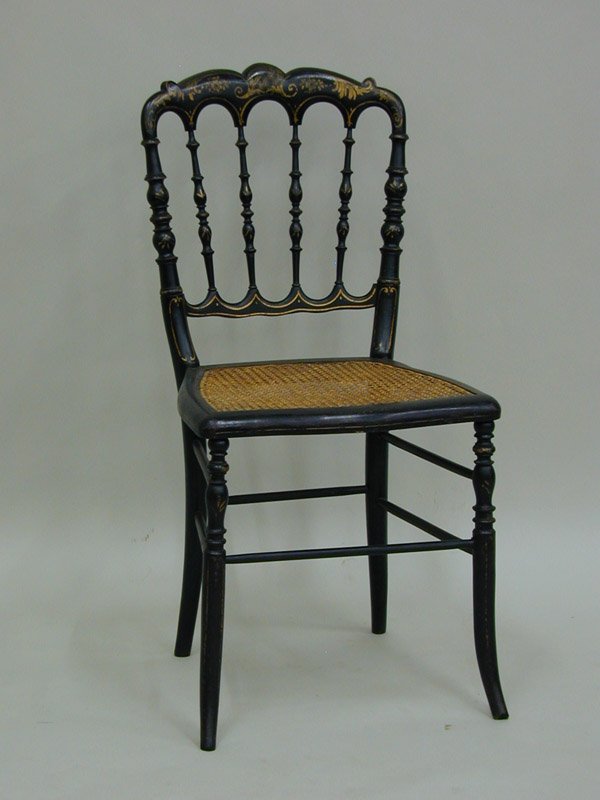 Napoleon III ebonized music chairs: (lot of 2) Similar Napoleon III ebonized music chairs, circa 1870, the first with a cusp crest above four spindles, over a caned seat, raised on slightly curved legs, the second of similar form, but i