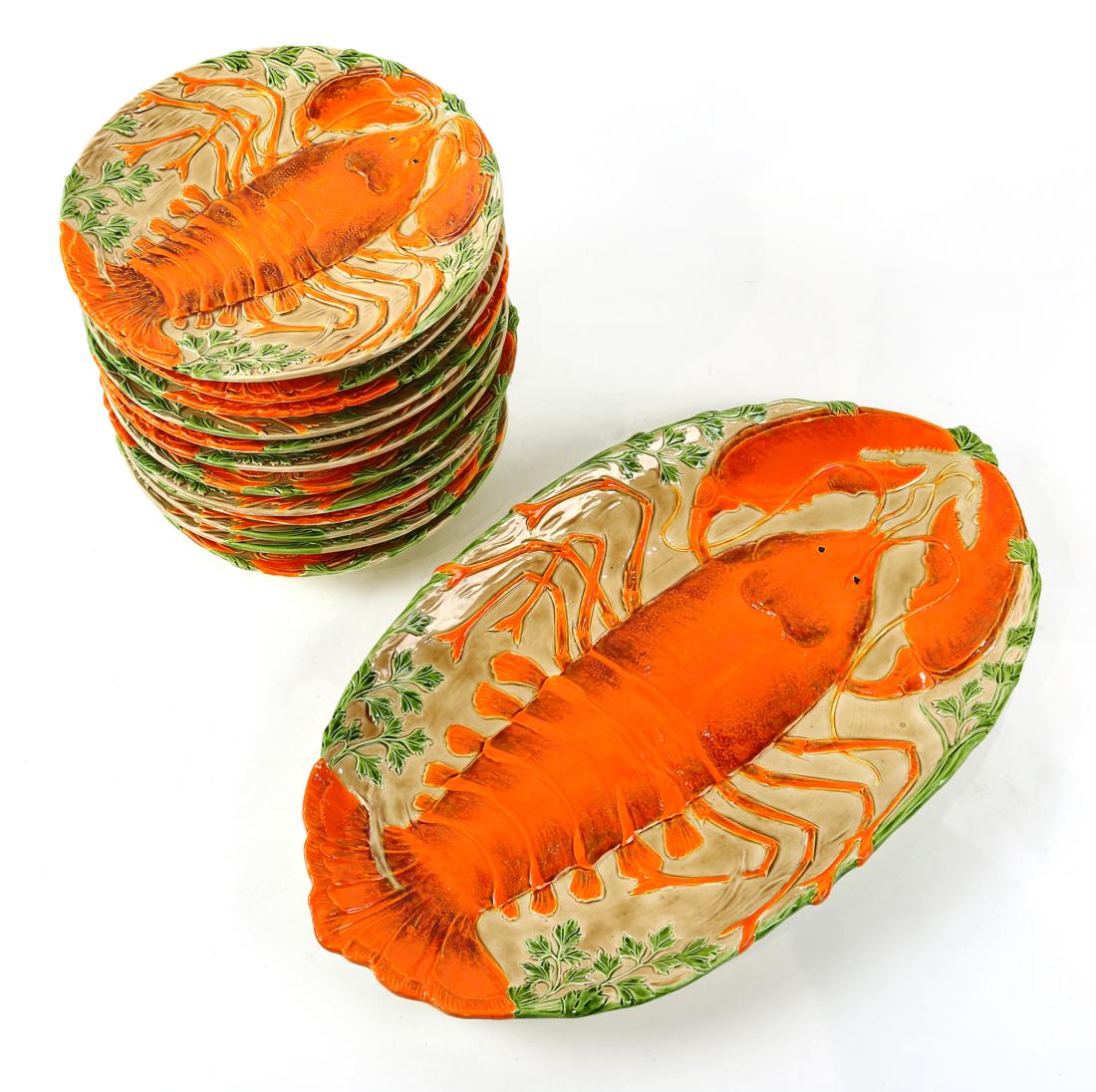 (lot of 13) Lobster majolica fish set: (lot of 13) Lobster majolica fish set, each centered with an orange lobster on a red ground, consisting of (12) plates, 9"dia., and a large serving platter, 18.5"l