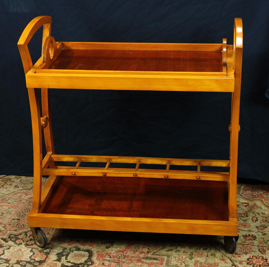 Rare Viennese Secession acacia and walnut bar cart on: Rare Viennese Secession acacia and walnut bar cart on wheels, designed by Joseph Hoffman, having handled sides above a removable tray, continuing to a lower tier with a serving shelf, and rising on wh