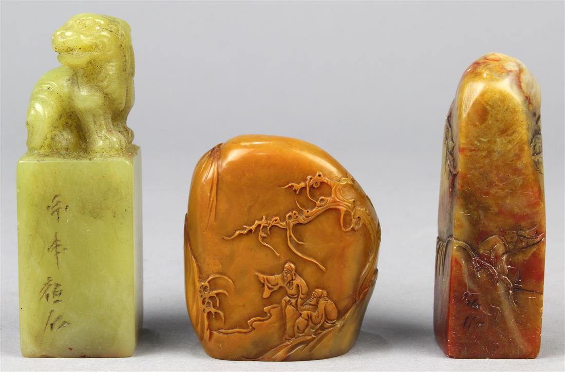 Chinese Soapstone Seals: (lot of 3) Chinese soapstone seals: first, of honey hue pebble carved with scholars in landscape; second, tall russet mottled plinth featuring figures; third, a green seal with a mythical beast, large