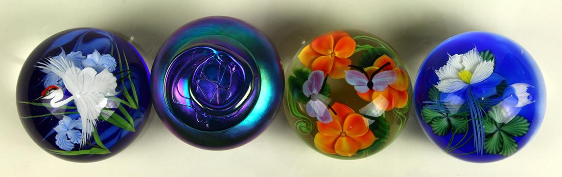 Lundberg Studios paperweight group: (lot of 4) Lundberg Studios paperweight group, consisting of (3) examples by Daniel Salazar, each having cased decoration, one with butterflies and flower accents, another with a crane, the last with 