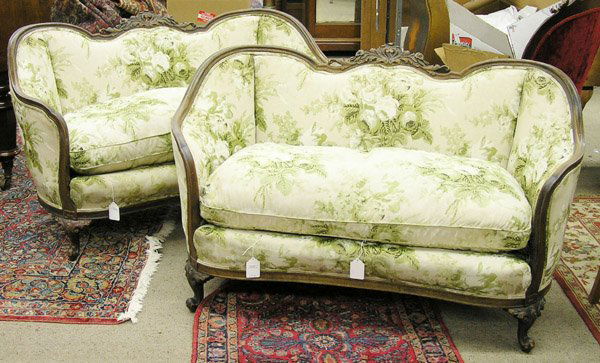 floral carved frame settees: Pair of floral carved frame settees with pierced floral crest and bowed arms on short cabriole legs, 32''h x 53''w x 31''d