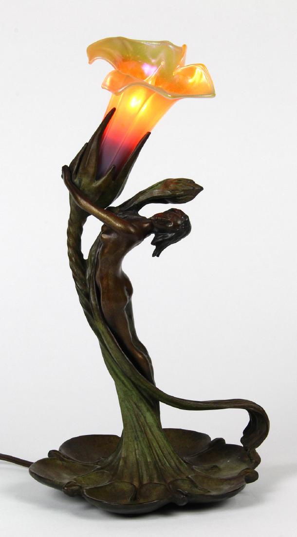 Art Nouveau patinated bronze desk lamp after Gustav: Art Nouveau patinated bronze desk lamp after Gustav Gurschner, having a single tulip form shade with a nude beauty leaning against the standard and bending backward, the whole rising on a floral form