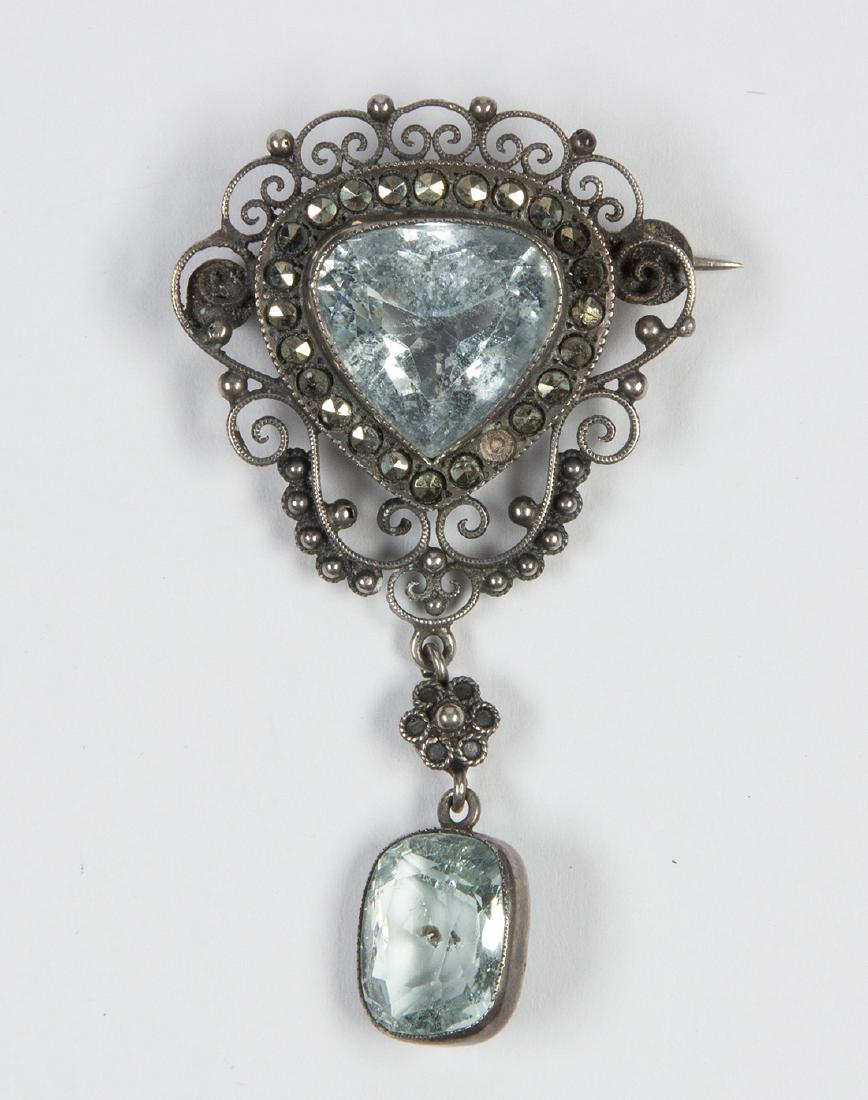 Aquamarine, marcasite and silver pendant-brooch: Aquamarine, marcasite and silver pendant-brooch Centering (1) triangular-cut aquamarine and suspending (1) cushion-cut aquamarine, weighing a total of approximately 11.20 cts., accented by marcasite, 