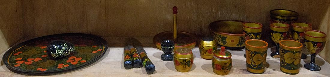 One shelf of Russian lacquer tableware including egg: One shelf of Russian lacquer tableware including egg cups, a serving plate, utensils, etc.