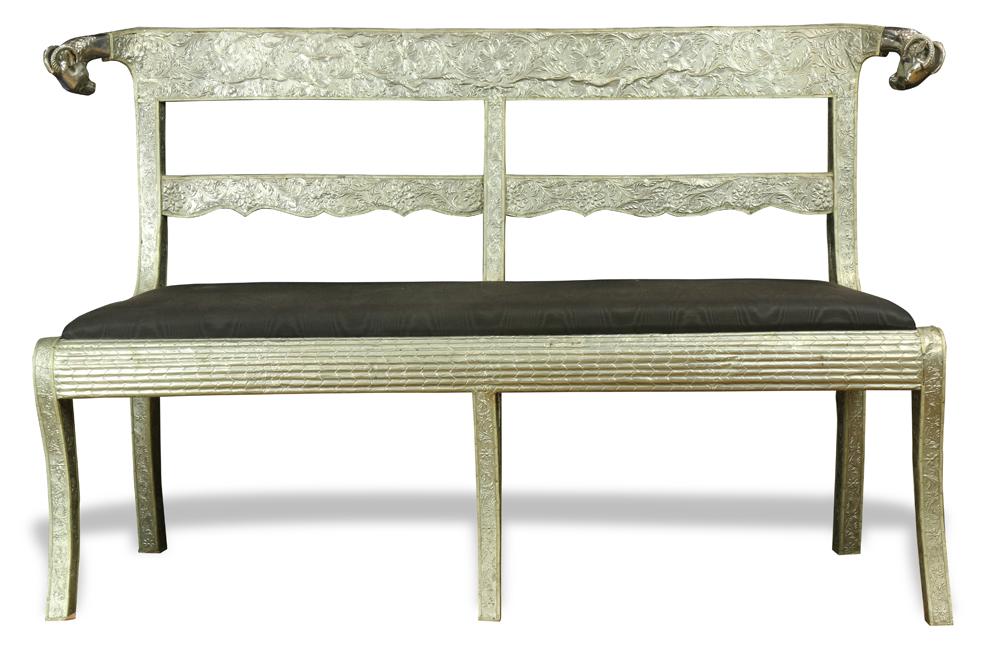 Anglo Indian silvered metal clad settee: Anglo Indian silvered metal clad settee, the silvered metal arched crest rail with repousse flowering vines, continuing to rams' head finials, the shaped rectangular slip seat rising on sabre legs, 34