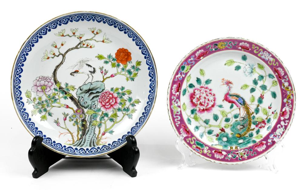Chinese Porcelain Plates, Birds and Flowers: (lot of 2) Chinese porcelain plates: first, with a phoenix amid peonies framed by a pink band with lotus and Buddhist treasures; second, featuring a crane amid peonies and magnolia, base marked 'Guang