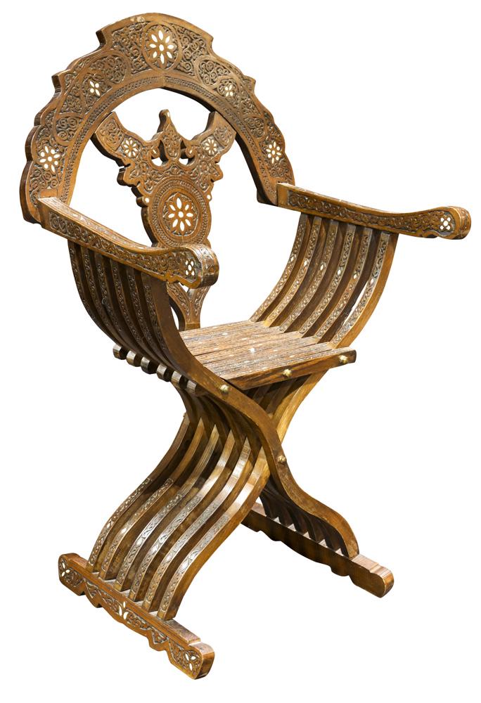 Syrian Levantine carved and inlaid armchair: Syrian Levantine carved and inlaid armchair, the shaped crest accented with mother of pearl and floral decotion, and rising on X-form legs, 42"h x 25.5"w Provenance: The Estate of Robin Leach, proceed