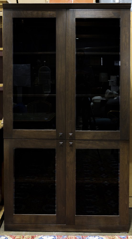 (lot of 2) Contemporary Arts & Crafts style ebonized: (lot of 2) Contemporary Arts & Crafts style ebonized oak stacking cabinets, the top cabinet with outset cornice molding in the front, over twin glazed doors, opening to reveal two shelves, over a shor