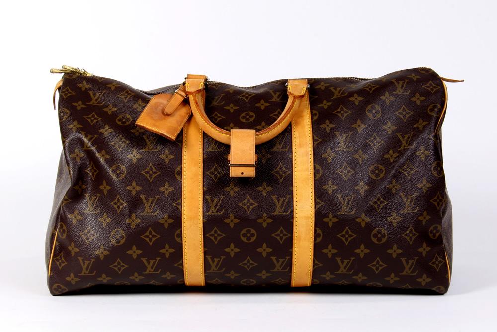 Louis Vuitton Keepall travel bag: Louis Vuitton Keepall travel bag, 50cm, executed in brown Monogram Coated Canvas and having luggage tag and handle strap, 50 x 26 x 22 cm