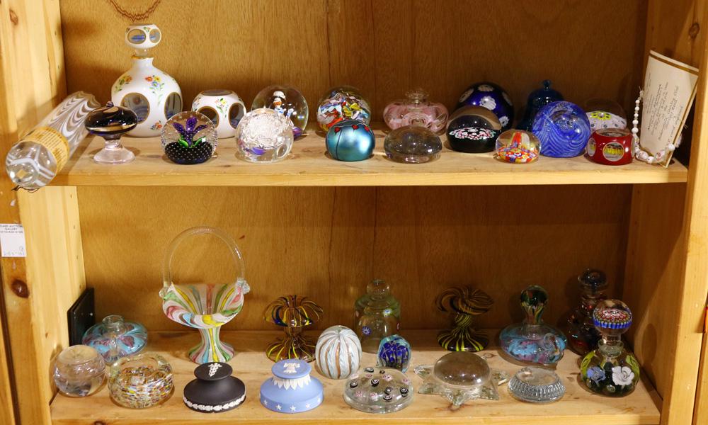 Two shelves of mostly paperweights by various makers: Two shelves of mostly paperweights by various makers, including Orient and Flume, Caithness, St. Clair, some having a mille fiori pattern