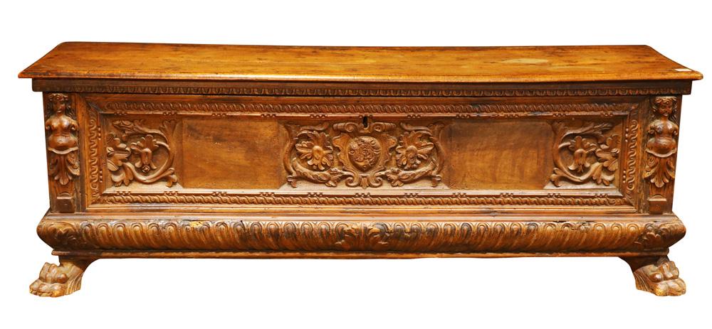An Italian cassone circa 1750: An Italian cassone circa 1750, having a rectangular top above the relief carved case with figural pilasters flanking the shield and floral form medallion, and resting on carved paw feet, 24"h x 66"w x