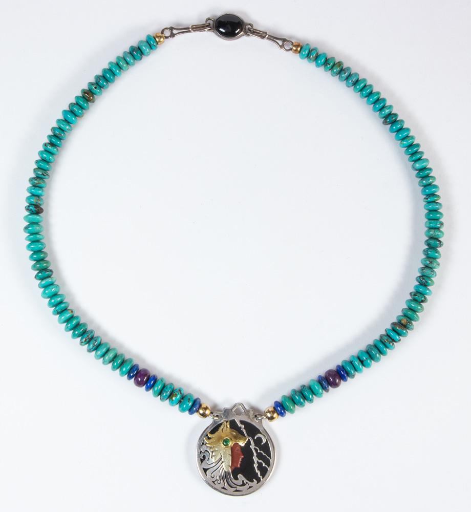 Heyoka Merrifield multi-stone, silver, gold necklace: Heyoka Merrifield multi-stone, silver, gold necklace Designed with a carved jasper face, wearing a Native American wolf headdress, accented by (1) round emerald cabochon, on a black onyx disc backgrou