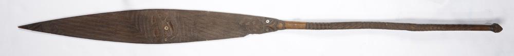 Maori carved paddle: Maori carved paddle, New Zealand, the long, finely carved and elaborate paddle with well formed handle and three bends to shank, the broader portion with incised faces and inlaid shell eyes, (crack an