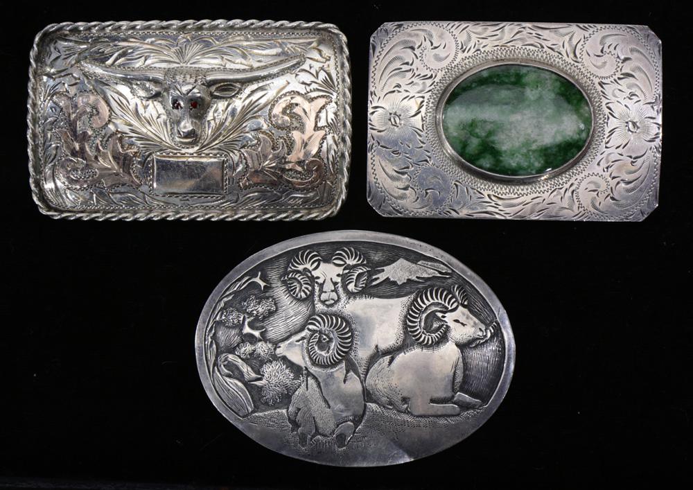 (lot of 3) A Southwest silver belt buckle lot: (lot of 3) A Southwest silver belt buckle lot: a Navajo oval sterling buckle with rams by Hyson Craig; the second, a Mexican sterling and mixed metal inlaid buckle featuring a cow skull with "JFCM" si