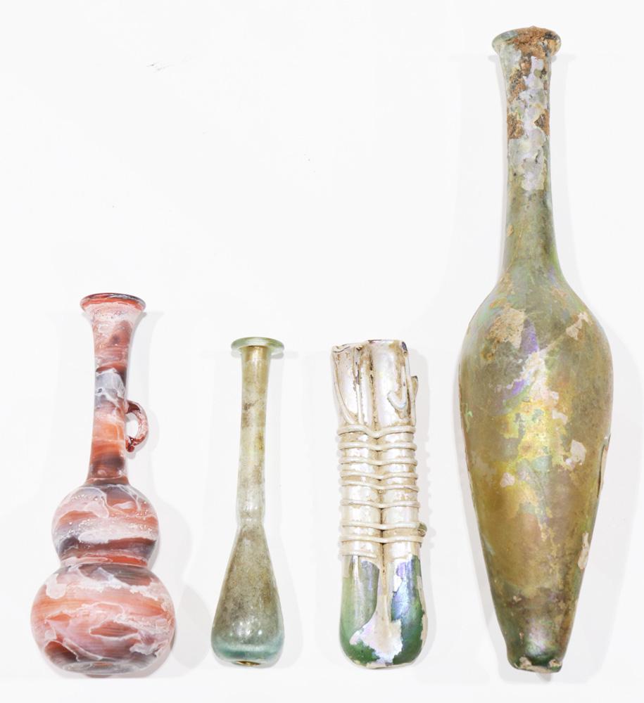 A Roman glass group: (lot of 4) A Roman glass group, consisting of a double Unguentarium vessel, in opaque irridescent to green glass, together with a stick neck vessel, another have a gourd form, and the largest having a