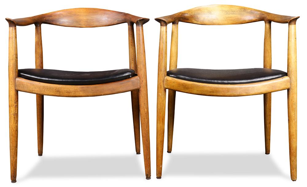 A group of Hans Wegner "The Chair" Modern arm chairs: (lot of 2) Hans Wegner "The Chair" Modern arm chairs, each having a shaped back, above a black upholstered seat and rising on tapered legs, unmarked, 29.5"h x 24.5"w x 18.5"d