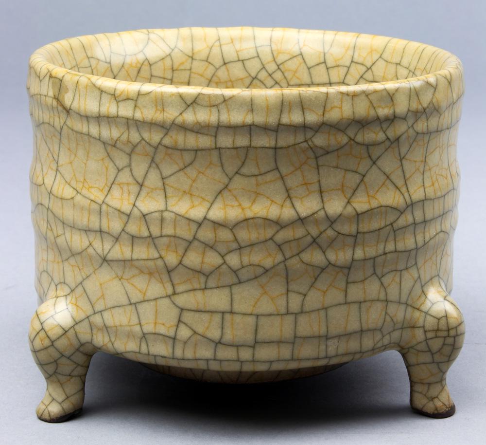 A Chinese Ge-type Cylindrical Tripod Censer: A Ge-type cylindrical tripod censer, of cylindrical body decorated with bow string bands and set on three cabriolet feet, covered all over in an ash-grey glaze suffused with dark-grey and golden russe