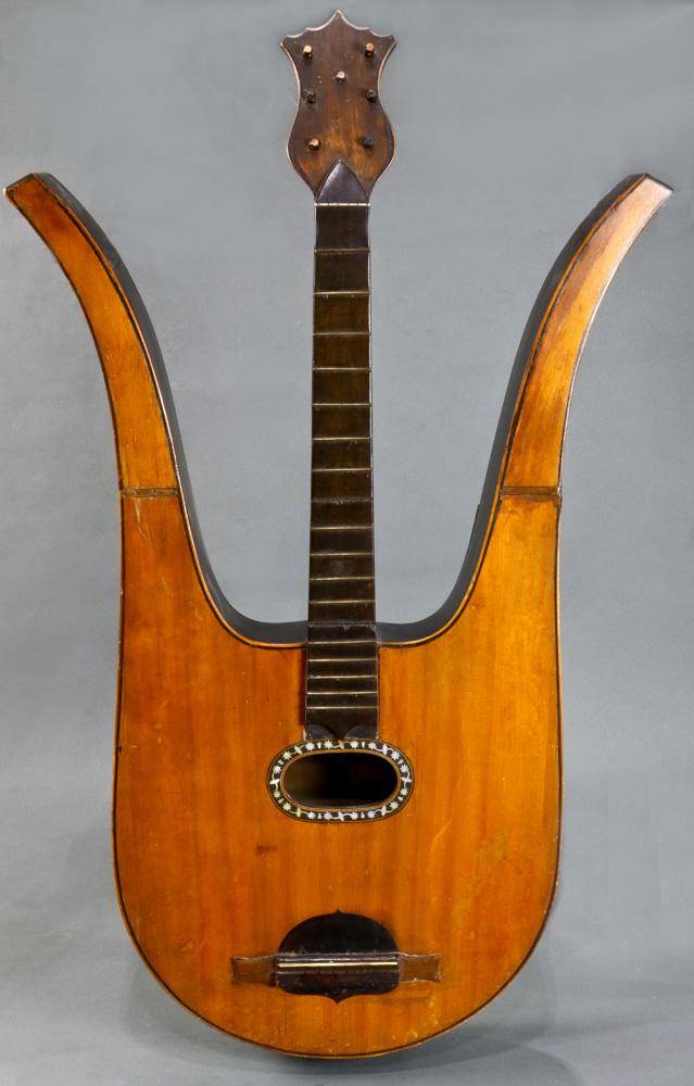 An Italian Alessandro Radizzani mixed wood and mother: An Italian Alessandro Radizzani mixed wood and mother of pearl inlaid lyre guitar (Chitarra Lyra), the lyre shaped case enclosing a shell inlaid sound hole, shield medallion saddle, 35"h x 21"l x 3"d 