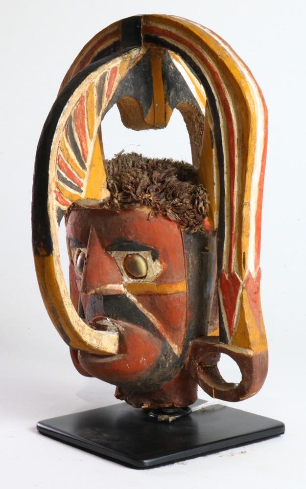 A head fragmented from a larger Malangan sculpture: A head fragmented from a larger Malangan sculpture, New Ireland, of fine older workmanship, probably pre-WWII, polychrome with a rust-red dominating, hair of plant fiber, 8.5"h Provenance: Sotheby's a