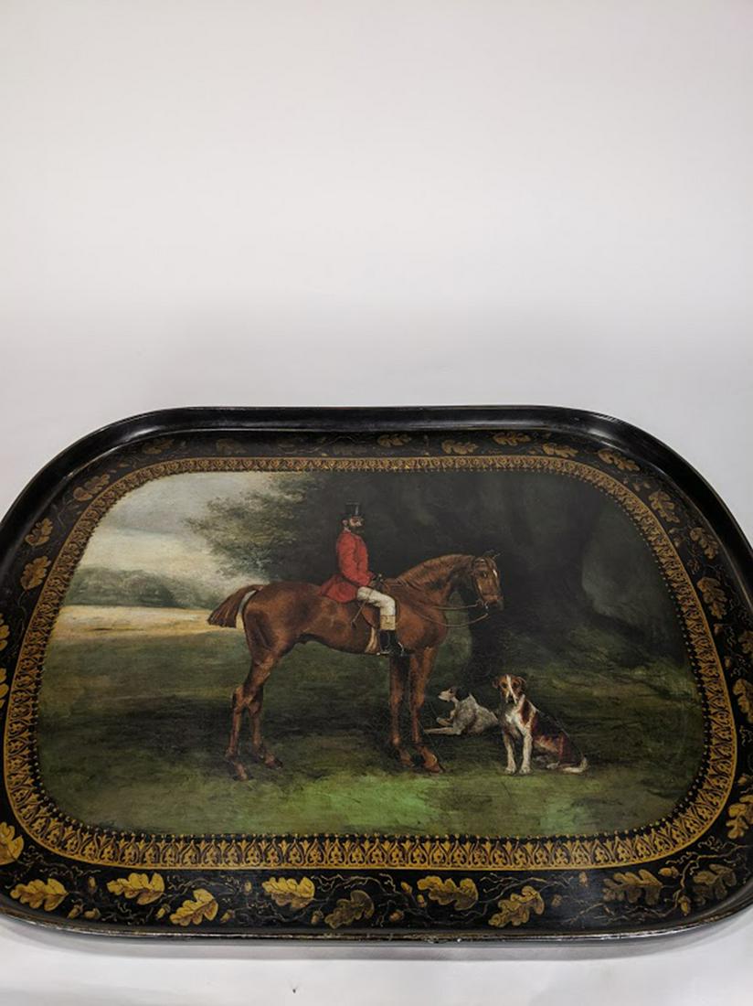An Early American Mark Knowles and Sons hand-painted: An Early American Mark Knowles and Sons hand-painted hunting tray, decorated with a scenic reserve centered with a hunter on horseback beside a pair of beagles, on a black lacquered ground with a gilt