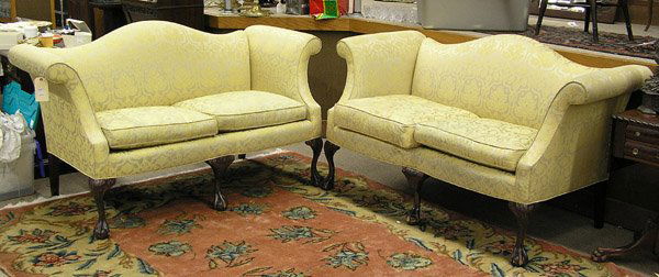 Chippendale style two-cushion settees: Pair of camel back Chippendale style two-cushion settees with yellow damask upholstery, each upon five legs having carved knees and ball and claw feet, 37''h x 65''w x 31''d, from the Ritz Carlton, Sa