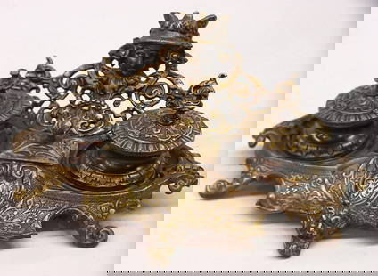 Patinated brass inkwell sets: Patinated brass inkwell set with reticulated floral decoration, supporting a mask of Mercury, the whole on scrolled and grotesque feet