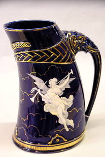 British Victorian cobalt pitcher: Late 19th c. British cobalt pitcher, with elephant handle and enameled herald against gilt clouds, the obverse decorated with an enameled swallow, 12''H, repairs to enamel on herald and swallow