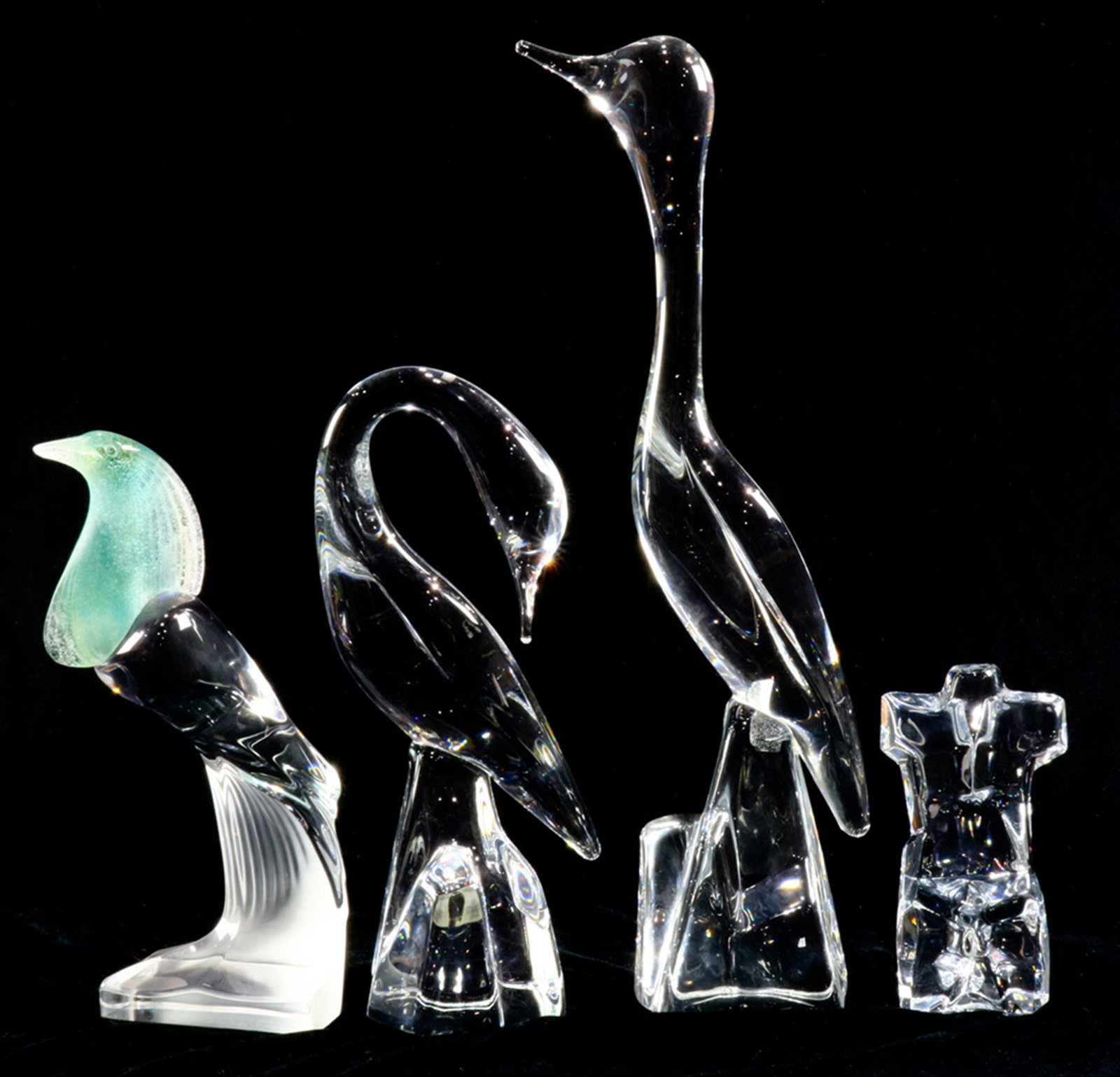 A Daum France crystal group: (lot of 4) A Daum France crystal group, two depicting heron executed in clear, together with a sea green pate de verre example continuing to clear, each script signed Daum France; together with an uns
