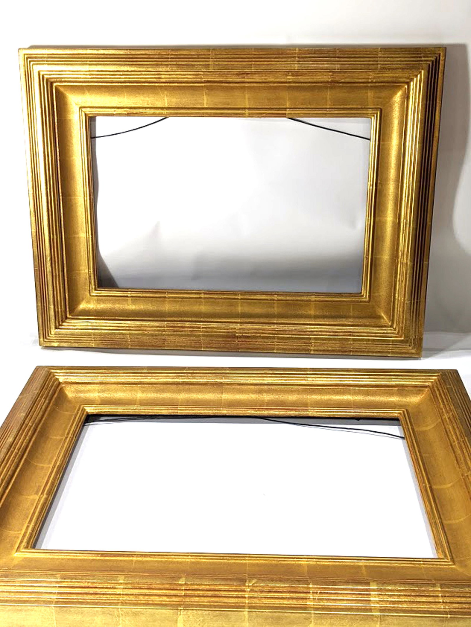 A pair of contemporary custom giltwood carved picture: A pair of contemporary custom giltwood carved picture frames, each with mark from Carmel, CA gilder verso overall 23"h x 31.5"w rabbet 14"h x 22"