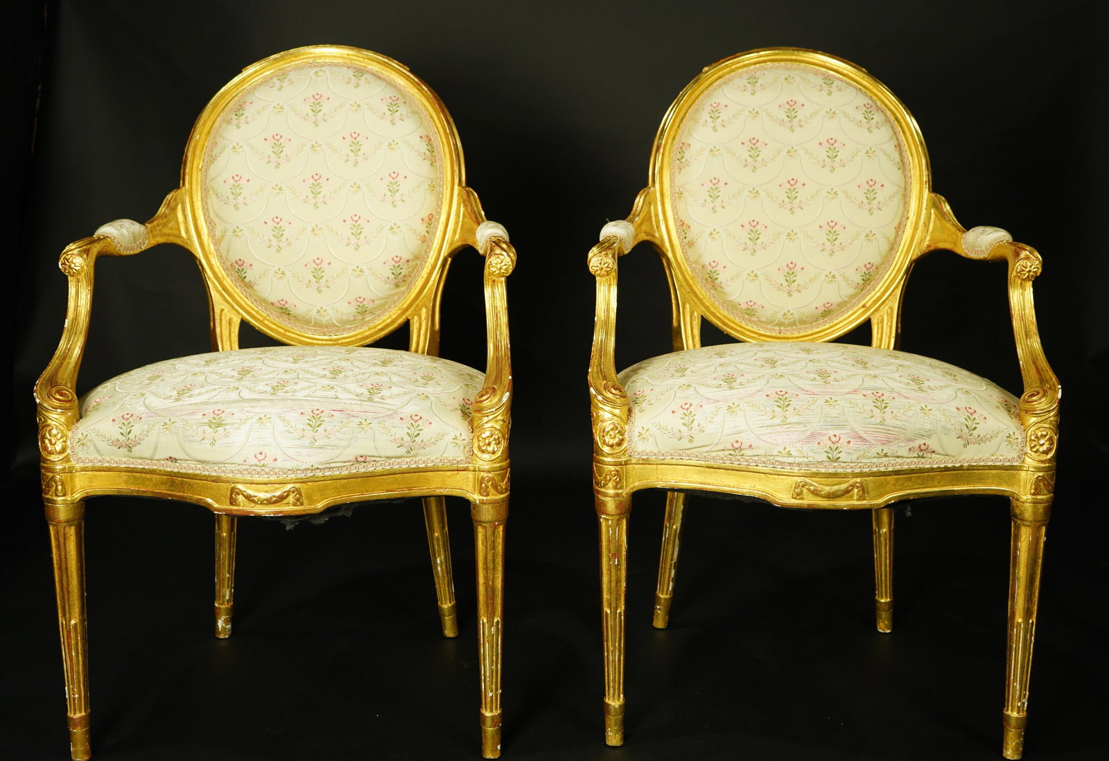 A pair of George III giltwood armchairs circa 1790: A pair of George III giltwood armchairs circa 1790, each having a circular back and rising on carved cabriole legs, 37"h Provenance: Property from the Estate of Frank J. Caufield, San Francisco (CA) a